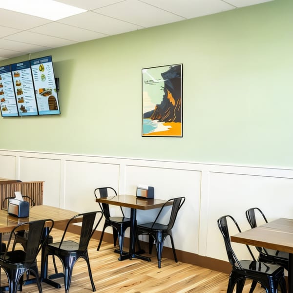 Legends Pacific Island Grill dining area with light green walls, wooden tables, and black chairs.
