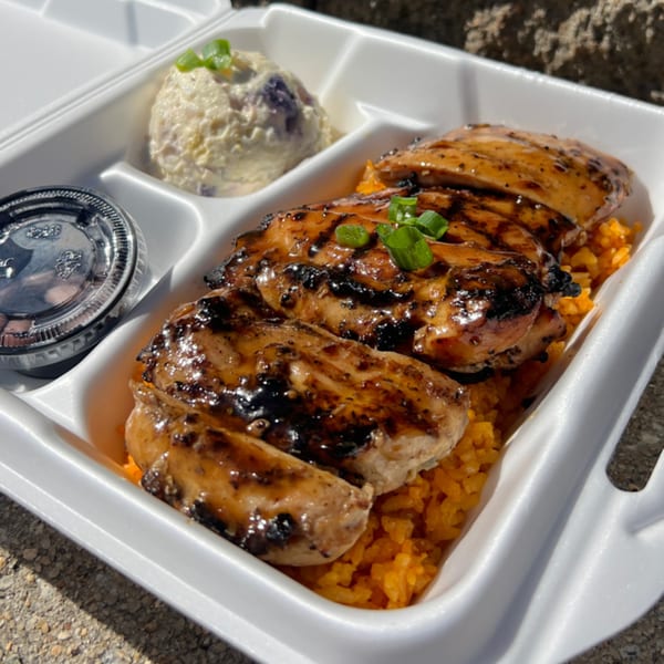 Legends Pacific Island Grill's teriyaki chicken, orange rice, and macaroni salad in a takeout container.